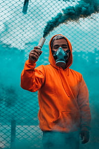 man with gas mask holding blue smoke flare thumbnail