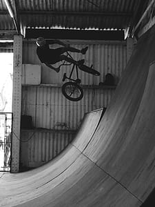 grayscale photography of man riding BMX bike thumbnail