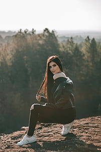woman wearing black off-shoulder top and jacket sitting on cliff thumbnail