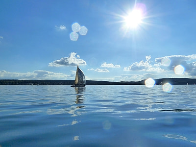 sailboat in the middle of body of water under calm sky thumbnail