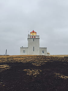 white and red lighthouse on field thumbnail