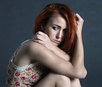 woman leaning against gray wall thumbnail