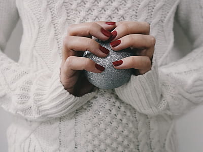 person wearing white sweater holding glitter ball thumbnail