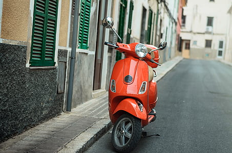 orange motor scooter parking near sidewalk at daytime thumbnail