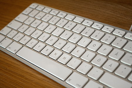 white Apple keyboard on brown surface thumbnail