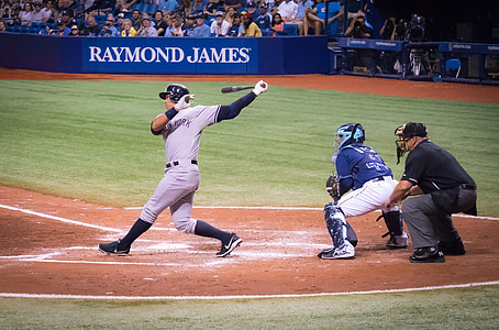 baseball player holding baseball bat standing on baseball field thumbnail
