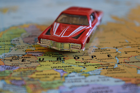 vintage red die-cast toy car on political map thumbnail