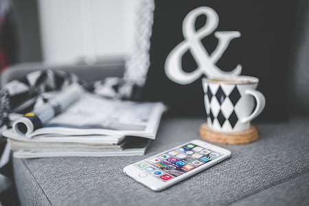 iPhone near white and black mug and book thumbnail