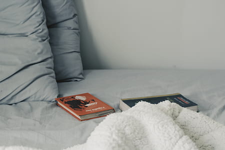 two assorted-title books on bed thumbnail