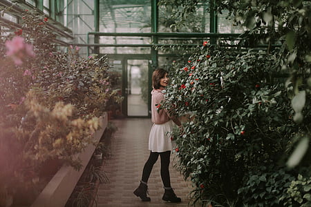 woman standing near green plants thumbnail