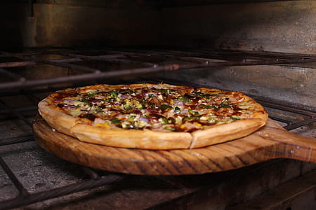 baked pizza on brown wooden pizza pan putting on oven thumbnail