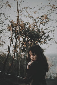 woman standing near trees during daytime thumbnail