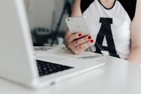 Businesswoman uses her mobile phone at her desk thumbnail