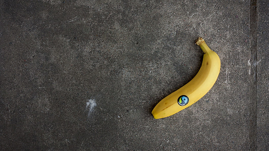 ripe banana on gray asphalt surface thumbnail