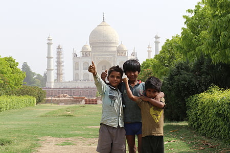three childrens standing near Taj mahal during daytime thumbnail