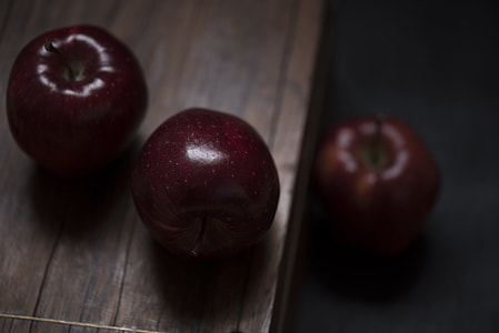 selective focus photography of two red apple fruits on brown wooden table thumbnail