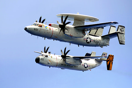 two white Navy planes flying under blue sky during daytime thumbnail