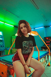 woman sitting on multicolored arcade game table thumbnail