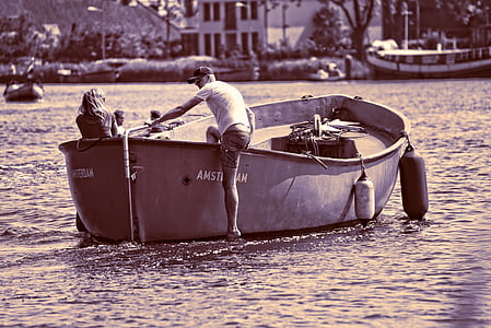 man climbing aboard boat on river in city thumbnail