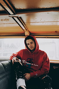 man wearing red pullover hoodie and black pants thumbnail
