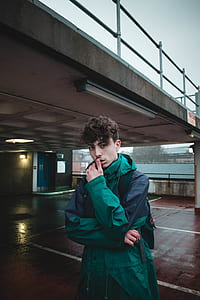 man standing under bridge during daytime thumbnail