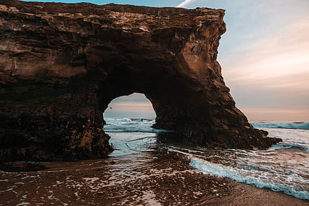 brown rock formation island during daytime thumbnail
