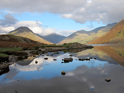 grass field beside calm body of water thumbnail