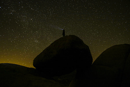 silhouette of person on rock formation during nighttime thumbnail