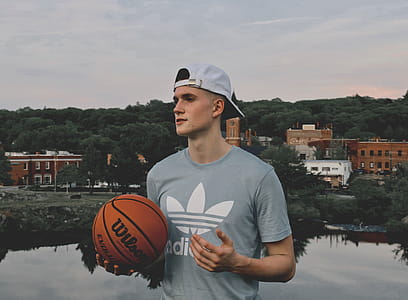 Man Wearing Gray Crew Neck Shirt Holding Basketball thumbnail