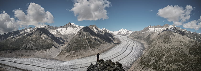 person standing on mountain beside road at daytime thumbnail
