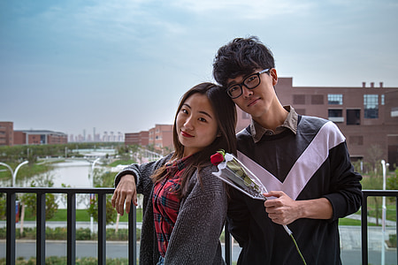 woman leaning on boy holding red rose flower bouquet thumbnail