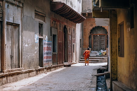 person in red shirt on concrete pavement near buildings thumbnail