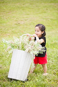girl wearing black sleeveless shirt holding basket of flowers thumbnail