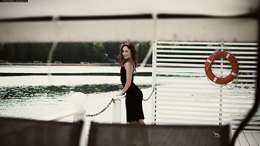 woman wearing black sleeveless dress near body of water thumbnail