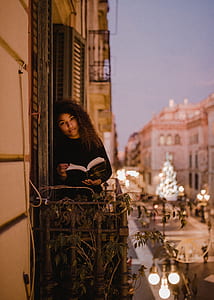 woman holding book on balcony thumbnail