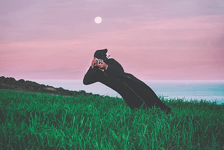 person holding camera on green grass thumbnail