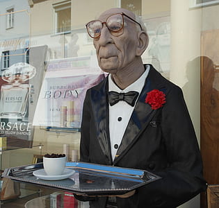 man holding tray statue in front of glass panel thumbnail