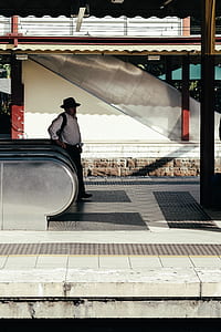 man standing beside escalator thumbnail
