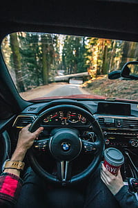 person driving BMW vehicle on road thumbnail