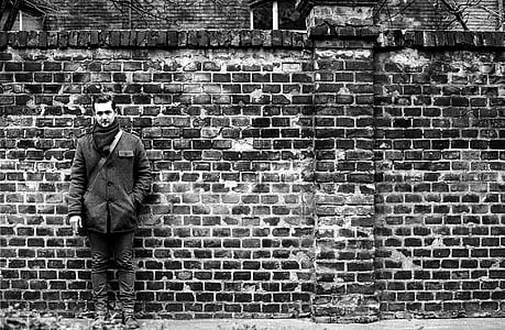 man leaning on bricked wall thumbnail