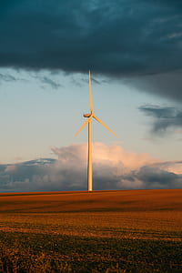 white wind turbine on the brown grass field thumbnail