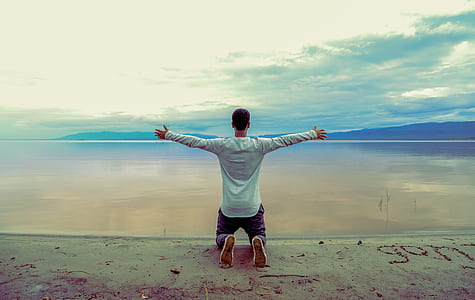 man kneeling on seashore thumbnail