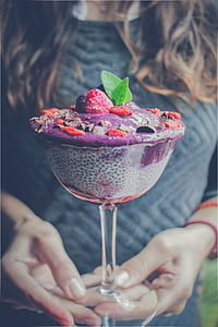 woman holding bowl of ice creams with strawberries and blueberries thumbnail