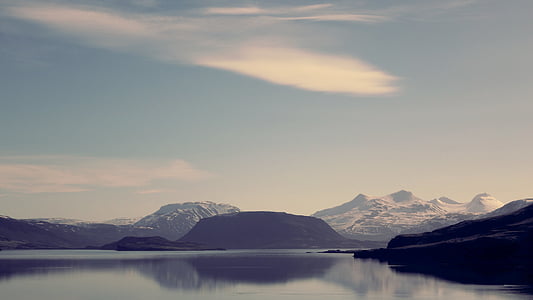 calm body of water surround with mountain at daytime thumbnail
