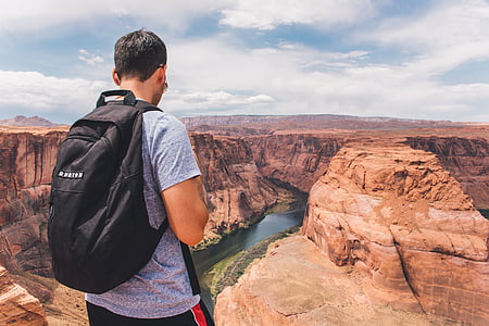 man in gray shirt and black backpack thumbnail