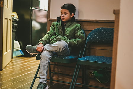 boy sitting on blue folding chair thumbnail