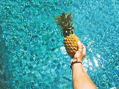 person holding pineapple fruit thumbnail