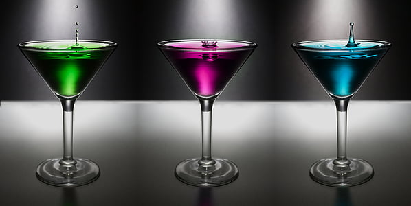 three cocktail glasses filled with assorted-color liquors thumbnail