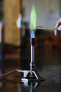 Copper solution burning on a wooden splint in a bunsen burner flame. thumbnail