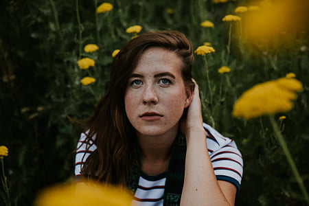 selective focus photography of woman sitting while holding her hair thumbnail